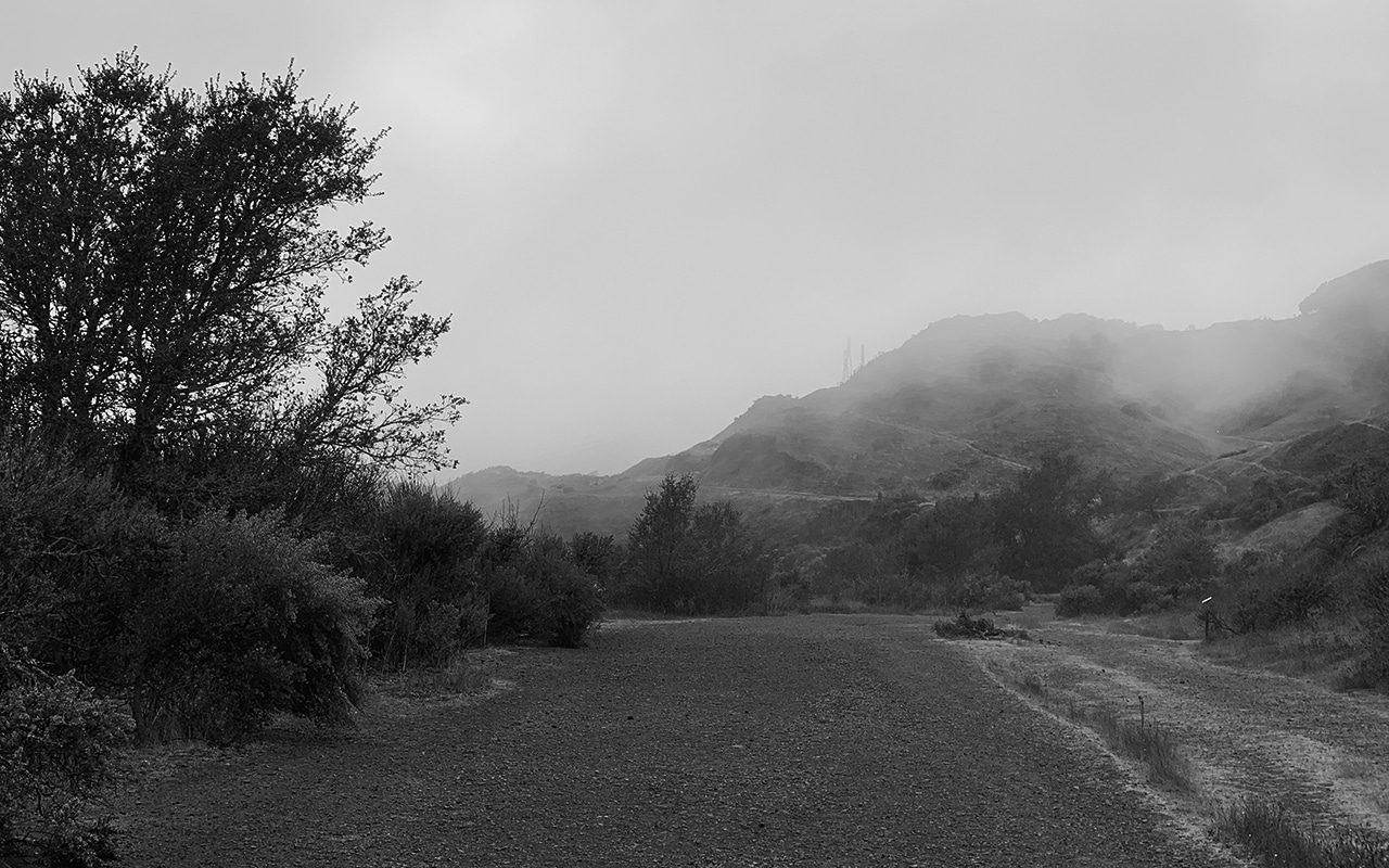 gravel path with mountain and fog in distance