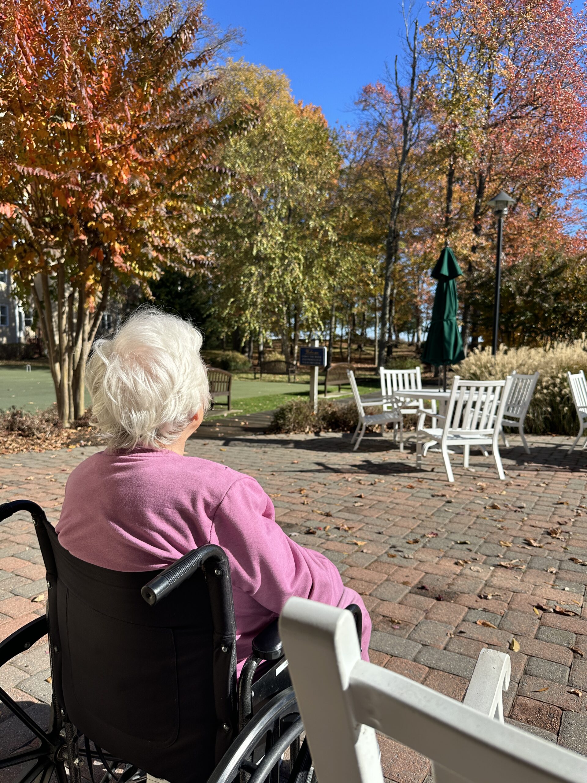 View of my mother sitting in a wheelchair staring up at the blue sky.